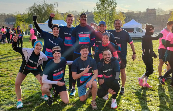 Groupe de coureurs joyeux posant pour une photo avant une course par une journée ensoleillée dans un parc.